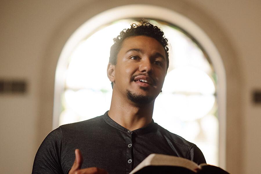 PBA student reads the bible at the front of chapel.